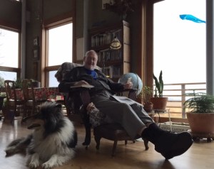 Steve Shoemaker in his favorite chair with Blazer, his collie by his side, his iPhone, book, and newspaper. Kite soaring outside the window