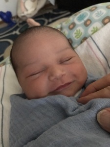 Elijah smiling in swaddle
