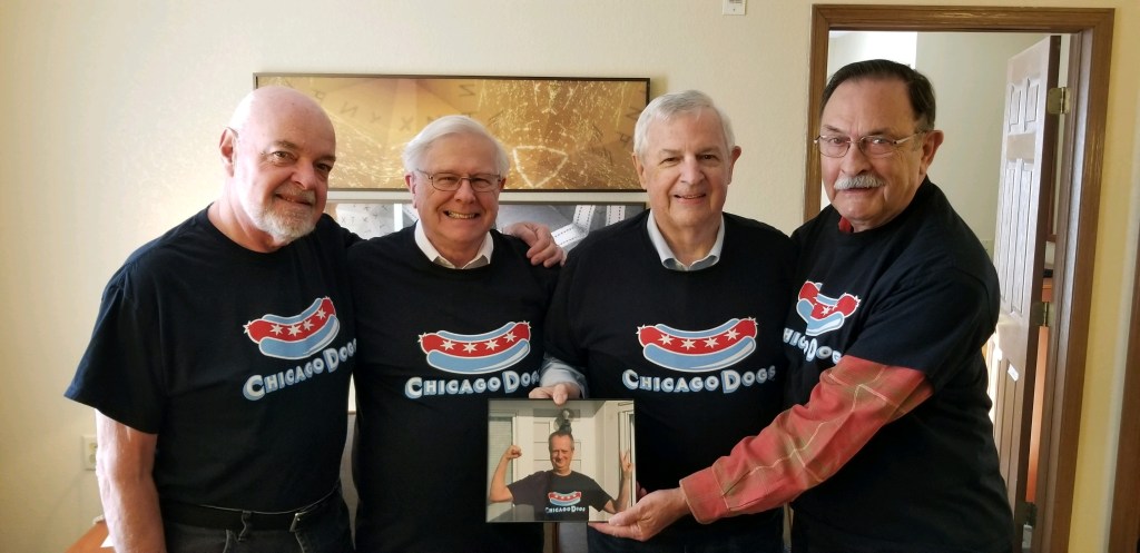 Photograph of four 'Old Dogs' with holding a picture of Wayne Boulton.